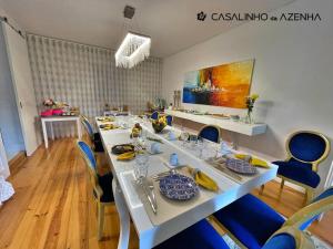 辛特拉Casalinho da Azenha - Charm House的一间带长桌和蓝色椅子的用餐室