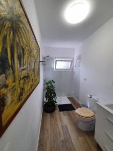拉克鲁斯Cozy and intimate bungalow in Puerto de la Cruz的一间带卫生间的浴室和墙上的绘画
