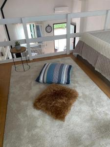 塞那哥La casetta的一间卧室配有一张床和一个带毛绒枕头的地毯