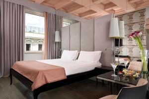 罗马罗马里昂宫酒店的一间卧室配有一张床、一张桌子和一个窗户。