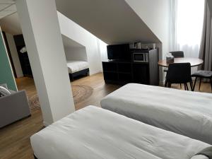 瓦卢瓦地区克雷皮Kyriad Crepy En Valois的酒店客房带两张床和一张桌子,还有一间房间