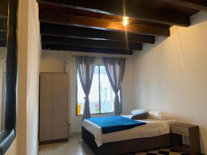卡塔赫纳Casa Hotel Marbella Beach的一间小卧室,配有床和窗户