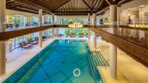 波亚纳布拉索夫Ana Hotels Bradul Poiana Brasov的一座大型游泳池,位于一座拥有大型天花板的建筑内