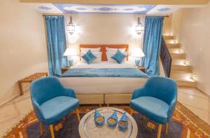 马拉喀什Riad El Hara的一间卧室配有一张床和两张蓝色椅子