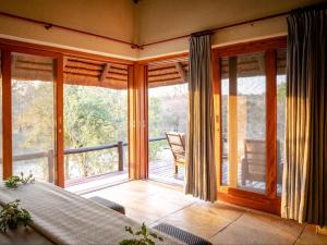 侯斯普瑞特Shimungwe Lodge的客房设有滑动玻璃门和阳台。