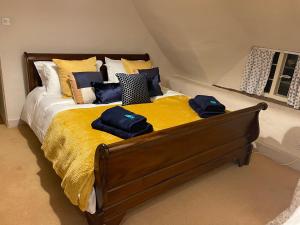 EnfordBeautiful Character Thatched Pet Friendly House的一张带黄色毯子和枕头的床