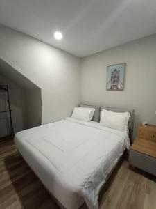 名古屋HOM Penuin Batam的卧室配有白色大床和白色枕头