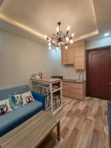 名古屋HOM Penuin Batam的一间带蓝色沙发的客厅和一间厨房
