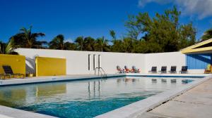 Stella Maris斯特拉马里斯度假俱乐部酒店的棕榈树白色建筑前的游泳池