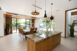 盛日社Cozrum Luxury - Aria Resort Vũng Tàu的厨房以及带桌椅的用餐室。