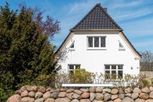格拉尔-米里茨Ferienwohnung BROMBEERE mit großem Garten und Balkon的黑色屋顶的白色房子