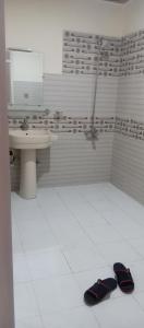 罕萨Venus Mountain Resort, Hunza的浴室设有水槽和2个拖鞋,位于地板上