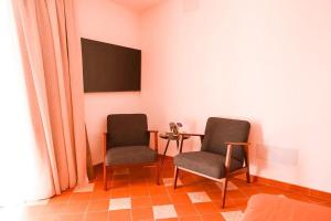 阿尔豪林格朗德Finca Besito的配有两张椅子的房间,配有一张桌子和一台电视机
