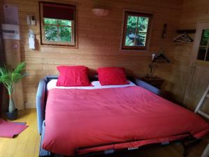 GagnyNormandy cottage的一间卧室配有一张红色大床和两个红色枕头