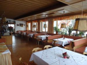 维尔德科格尔山麓布兰贝格Dorferwirt的餐厅配有桌椅和白色桌布