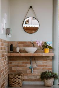 戈亚斯州上帕莱索João de Barro camping e suítes的浴室设有水槽和砖墙上的镜子