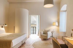帕拉弗鲁赫尔Can Mascort Eco Hotel的卧室配有床、椅子和窗户。