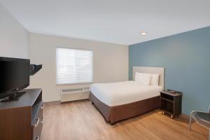 Extended Stay America Select Suites - Phoenix - North的一间卧室配有一张床和一台平面电视