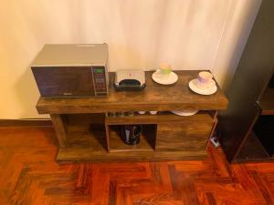 利马Iguana Haus Lima的一张带微波炉的木桌和盘子上的两个杯子
