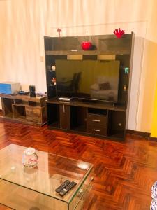 利马Iguana Haus Lima的客厅设有大电视和玻璃桌