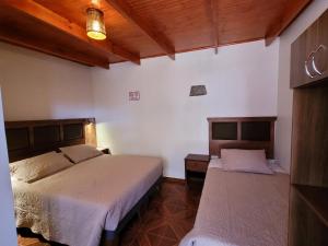 圣佩德罗·德·阿塔卡马Lalck Cketi Hospedaje y Turismo的一间卧室,配有两张床