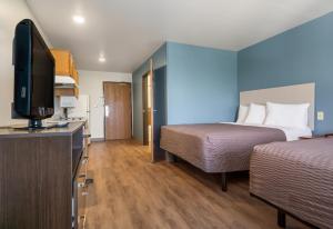 迈尔斯堡Extended Stay America Select Suites - Fort Myers的酒店客房设有两张床和一台平面电视。