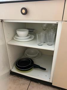 洛桑Apartamento Lausanne的橱柜里放着煎锅和盘子