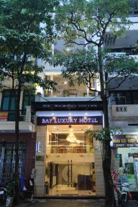 河内Bay Luxury Hotel - No 9 Nguyen Truong To, Ba Dinh, Ha Noi的城市街道上一家海湾豪华酒店前的商店