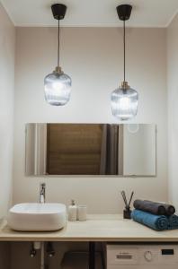 BrocēniRozenstein design residence的浴室内水槽上挂着两盏灯