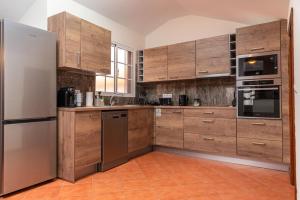 卡列塔CASA POR DO SOL的厨房配有木制橱柜和不锈钢用具