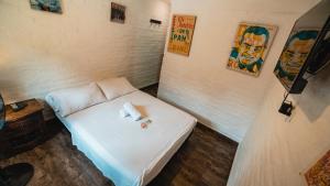 卡利Viajero Hostel Cali & Salsa School的一间小房间,里面设有白色的床