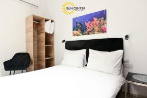 埃拉特Sun Center Eilat的一间卧室配有一张床和一张黑椅
