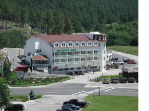 奇斯顿Roosevelt Inn Mount Rushmore的一座白色的大建筑,汽车停在停车场