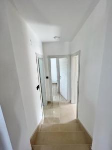苏佩塔尔Villa LONGO的房屋内带白色墙壁和楼梯的走廊