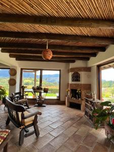 莱瓦镇Hotel, Bungalows, Chalet y Cabañas Aventura Park Villa De Leyva La Periquera的客厅配有桌椅和窗户。