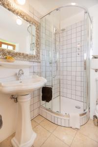 莱赫阿尔贝格Appartement Graf的带淋浴和盥洗盆的白色浴室