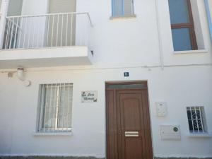 阿维拉CASA MARUJA的白色的建筑,设有棕色的门和楼梯