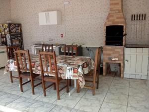 伊利亚孔普里达Ilha Comprida-Casa Madeira-Conforto Familiar的厨房配有桌椅和炉灶。