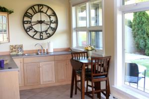 基洛纳Quail Ridge的厨房配有桌子和墙上的大时钟