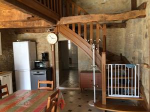 Castelnau-de-MandaillesLa Source Gilhodes的厨房设有楼梯和墙上的时钟