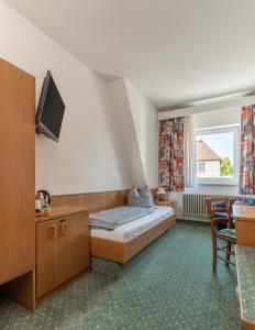 萨尔茨吉特巴德Hotel Kniestedter Hof的一间酒店客房,配有一张床和一台电视