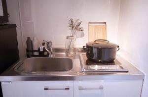 东京The Aoca Tokyo Sanno的厨房柜台设有水槽和炉灶上的锅子