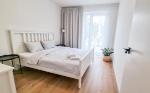 米库洛夫Dům na jihu Mikulov s finskou saunou的白色的卧室设有白色的床和窗户。