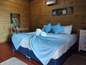 德尔迪阿布罗角Posada Las Maravillas的木制客房内的一间卧室,配有一张床