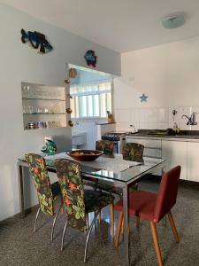 卡拉瓜塔图巴Apartamento a 50m da areia - Praia da Tabatinga的厨房配有餐桌和椅子