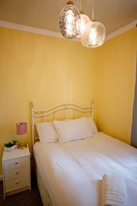 爱丁堡Cosy one bedroom flat in city center的一间卧室配有白色的床和两盏灯