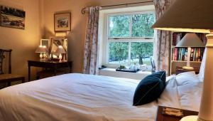 里彭Orchard Cottage的卧室配有白色的床和窗户。
