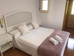 赫罗纳Casa Veuràs Girona - Montilivi的卧室配有白色的床和2条毛巾