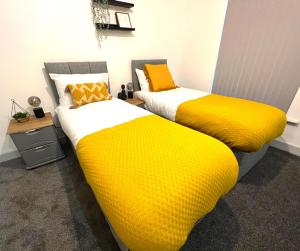 威根SA Stays的两张带黄色和白色床单的床