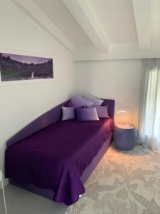 维罗纳Villa Il Bacio del Sole的一间卧室配有紫色床和紫色毯子